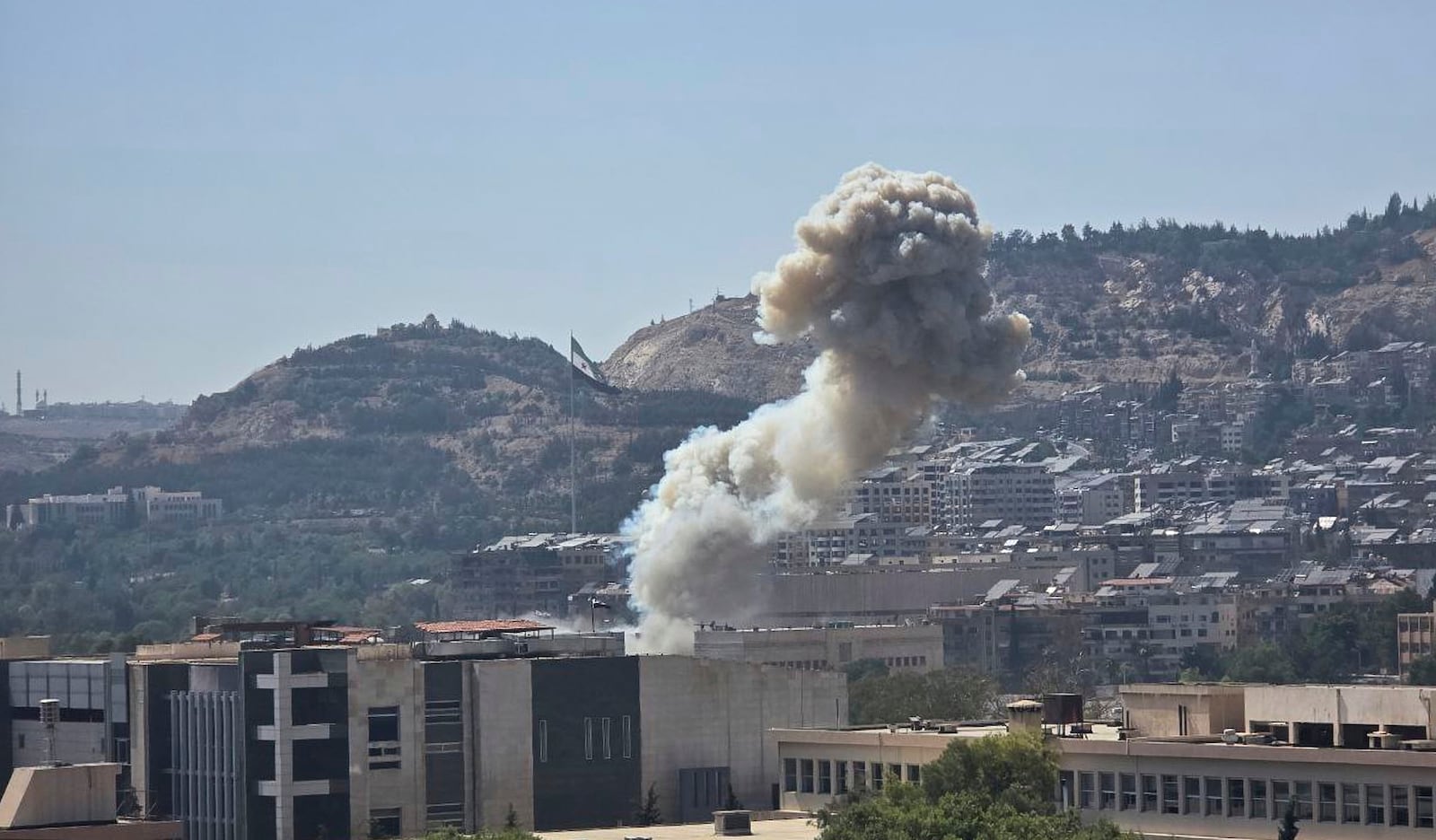 In this photo released by the Syrian official news agency SANA, smoke rises from an Israeli airstrike that hit the Syrian Defense Ministry in Damascus, Syria, Wednesday, July 16, 2025. (SANA via AP)