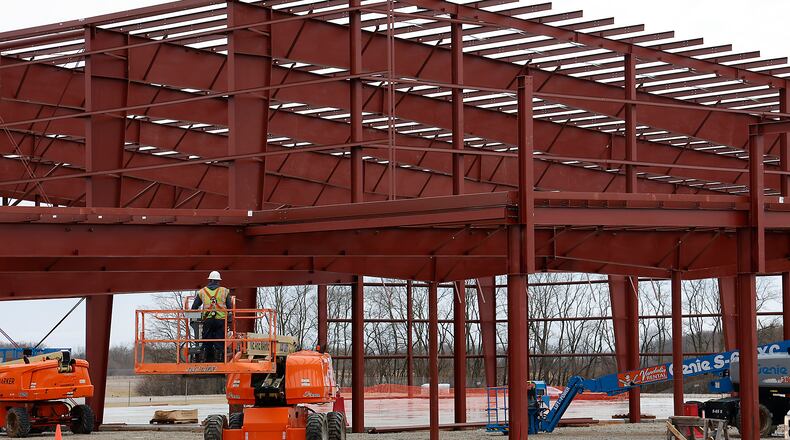 A worker maneuvers a lift into place as work continues on the National Advanced Air Mobility Center of Excellence at the Springfield Beckley Airport Thursday, Feb. 16, 2023. BILL LACKEY/STAFF