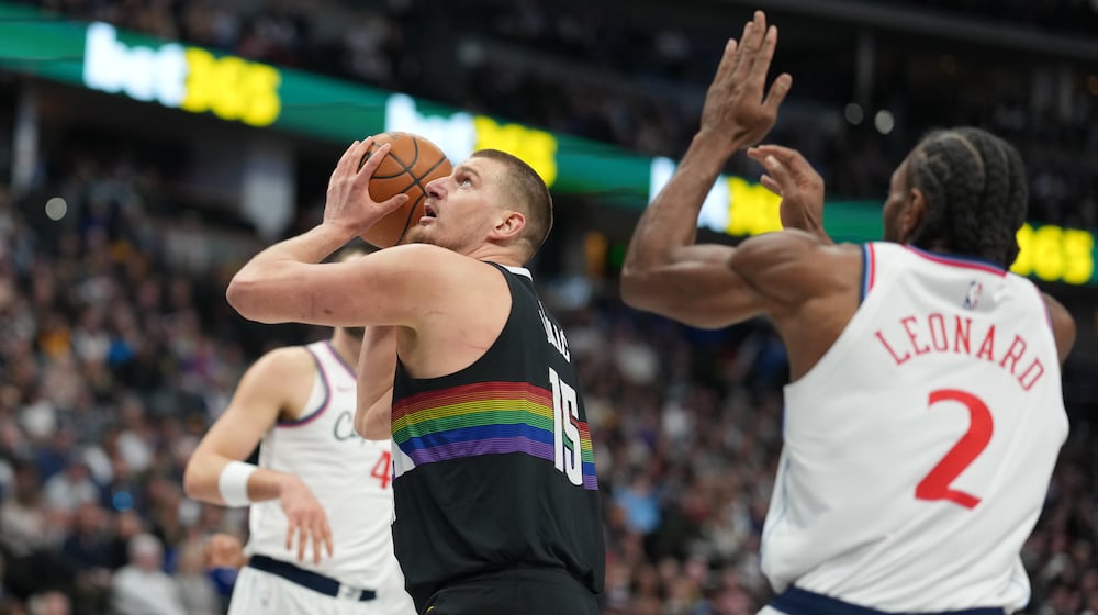 Denver Nuggets center Nikola Jokić (15) goes up for a basket as Los Angeles Clippers forward Kawhi Leonard (2) defends in the first half of an NBA basketball game Friday, Jan. 30, 2026, in Denver. (AP Photo/David Zalubowski)