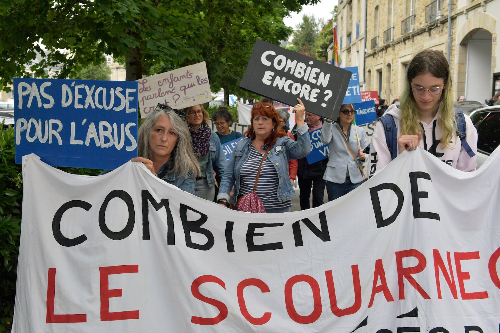 People demonstrate with a banner reading "How many Le Scouarnec" ahead of the verdict in the trial of Joel Le Scouarnec, a 74-year-old former surgeon, accused of raping and sexually assaulting 299 children, Wednesday, May 28, 2025 in Vannes, Brittany, western France. (AP Photo/Mathieu Pattier)