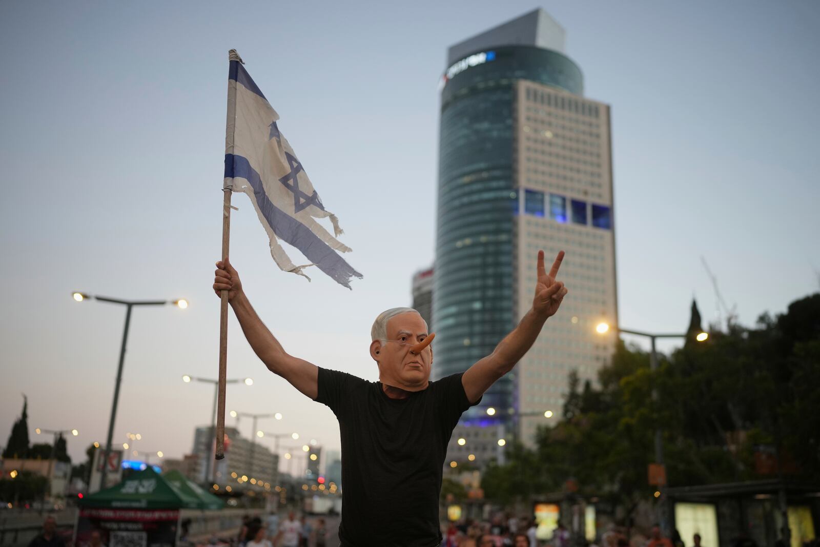A demonstrator takes part in a performance during a protest against Prime Minister Benjamin Netanyahu's government and call for the release of hostages held in the Gaza Strip by the Hamas militant group, in Tel Aviv, Israel, Saturday July 05, 2025. (AP Photo/Ohad Zwigenberg)