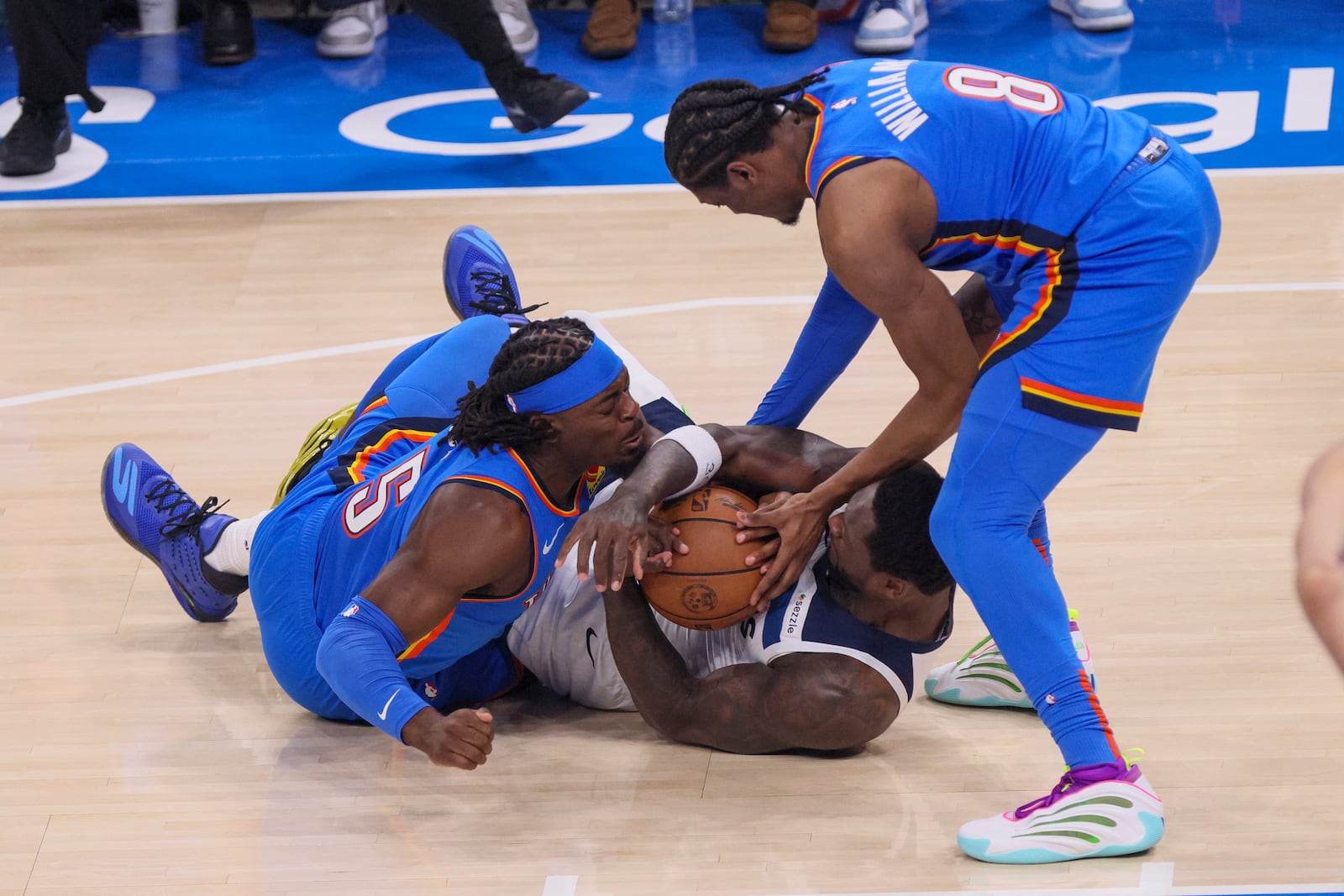 Minnesota Timberwolves forward Julius Randle, center, fights for the ball against Oklahoma City Thunder guard Luguentz Dort, left, and forward Jalen Williams during the first half of Game 2 of an NBA basketball Western Conference Finals playoff series Thursday, May 22, 2025, in Oklahoma City. (AP Photo/Nate Billings)