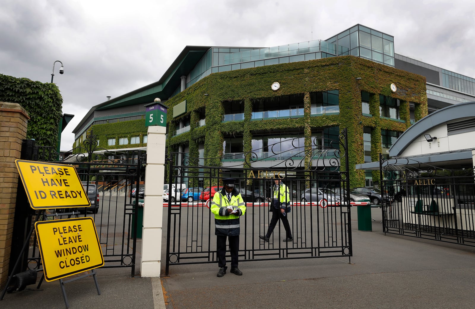 FILE - Security guards at the entrance in front of Centre Court at the All England Lawn Tennis Club in Wimbledon in London, Monday, June 29, 2020. (AP Photo/Kirsty Wigglesworth,File)