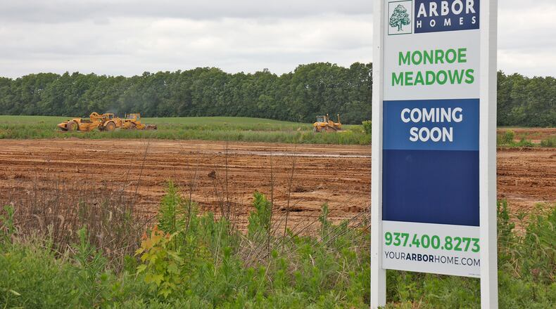 Earth moving machines get the site along Addison-New Carlisle Road ready for the new Monroe Meadows housing development Monday, June 10, 2024. BILL LACKEY/STAFF