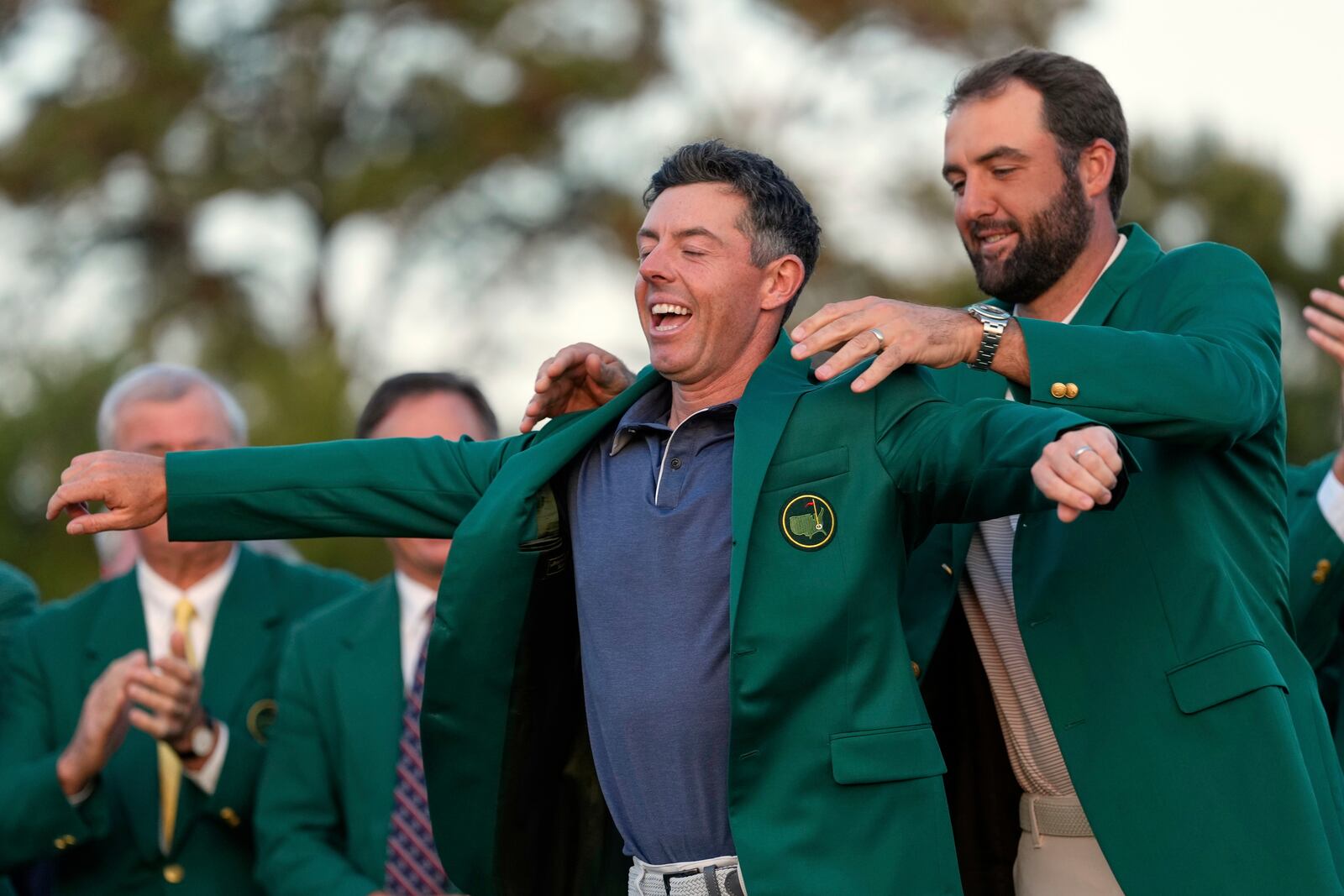 Scottie Scheffler puts the green Jacket on winner, Rory McIlroy, of Northern Ireland, at the Masters golf tournament, Sunday, April 13, 2025, in Augusta, Ga. (AP Photo/Ashley Landis)