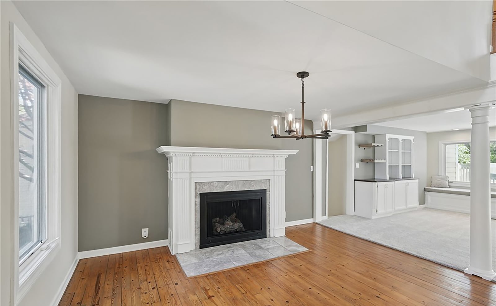 The living room has a fireplace and hardwood flooring and a ceiling light. CONTRIBUTED