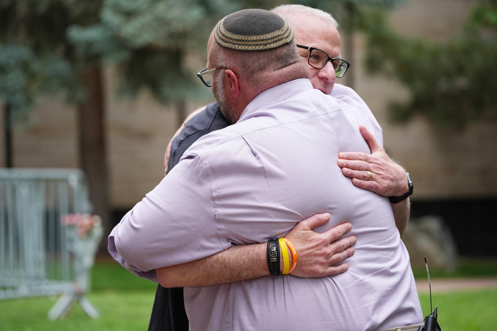 Rabbi Fred Greene of Congregation Har Hashem, front, hugs a man outside of the Boulder County, Colo., courthouse after Sunday's attack, Monday, June 2, 2025, in Boulder, Colo. (AP Photo/David Zalubowski)