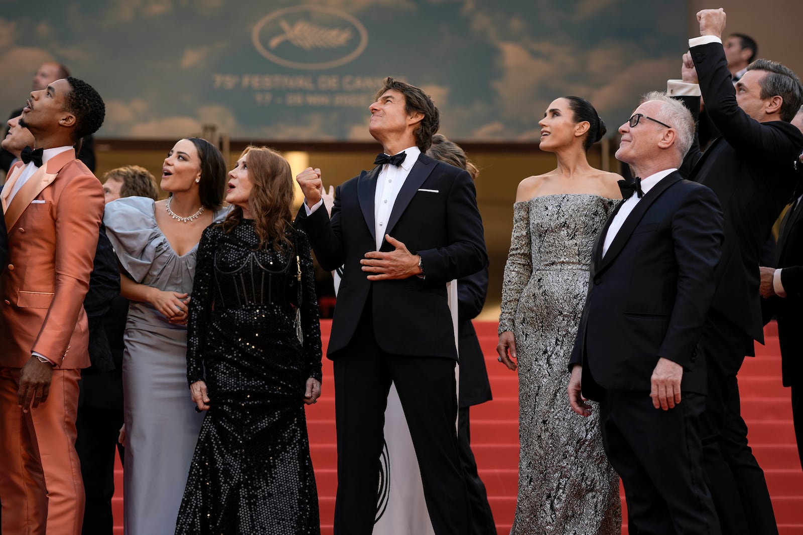FILE - Tom Cruise, center, poses with the Greg Tarzan Davis, from left, Keleigh Sperry, Linda Bruckheimer, Jennifer Connelly, festival director Thierry Fremaux, and Jon Hamm after French Alpha Jets Patrouille de France fly over the red carpet at the premiere of the film 'Top Gun: Maverick' at the 75th international film festival, Cannes, southern France, Wednesday, May 18, 2022. (AP Photo/Petros Giannakouris, File)