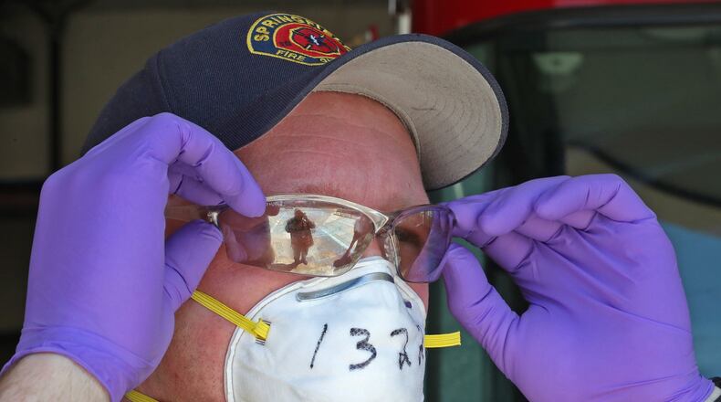Springfield firefighter Bryon Betsinger puts on his protective equipment Wednesday before a run. BILL LACKEY/STAFF