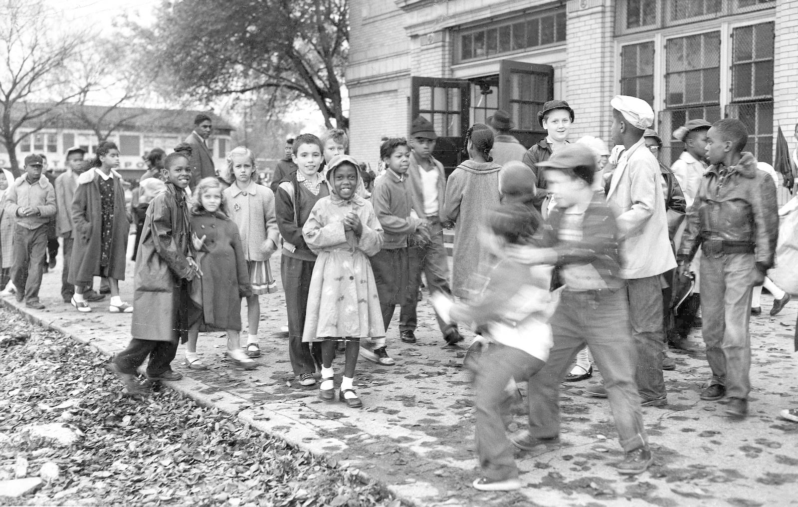 FILE - White and Black children mix freely on the playground outside a school in a racially mixed neighborhood, Oct. 18, 1957, in Detroit. (AP Photo/Alvan Quinn, File)