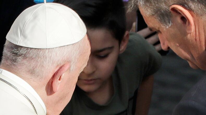 Pope Francis has his hands sanitized by his personal assistant during his weekly general audience general audience in San Damaso courtyard at the Vatican, Wednesday, Sept. 9, 2020. (AP Photo/Andrew Medichini)