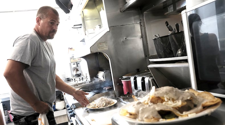 Jeff Wade, the owner and cook at Mobile Dogs Cafe, hard at work at the grill. Bill Lackey/Staff