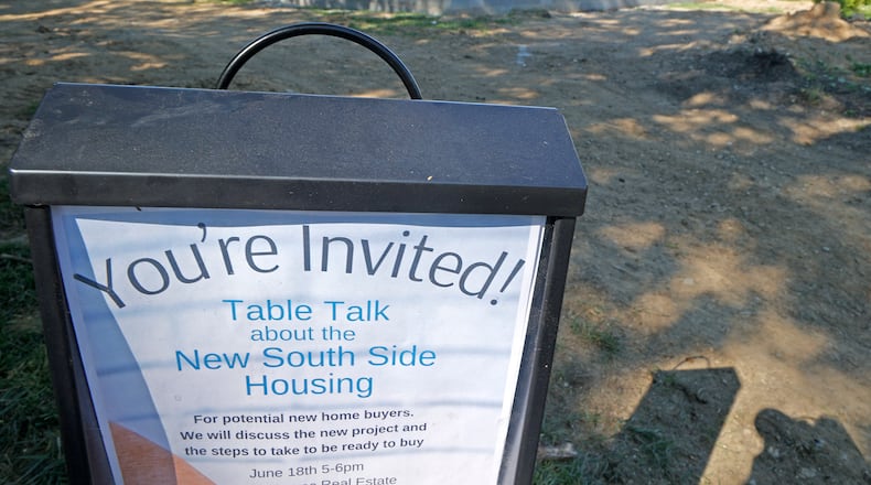 An invitation to a discussion regarding affordale new southside housing is placed along the edge of a construction site for a new house Wednesday, June 12, 2024 being built along South Yellow Springs Street. BILL LACKEY/STAFF