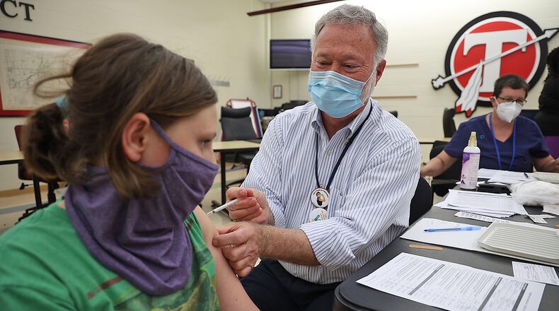 Dr. John Dobson gives Bella Handwerker, 12, her COVID vaccination during the COVID clinic at Tecumseh High School. BILL LACKEY/STAFF