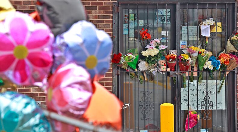 Flowers and balloons decorate the front of Gill's Quality Meat Market on Selma Road in Springfield Monday, Jan. 9, 2023 in a memorial for Thomas Gill, the owner of the meat market. Gill died January 5, after being shot in his SUV. BILL LACKEY/STAFF