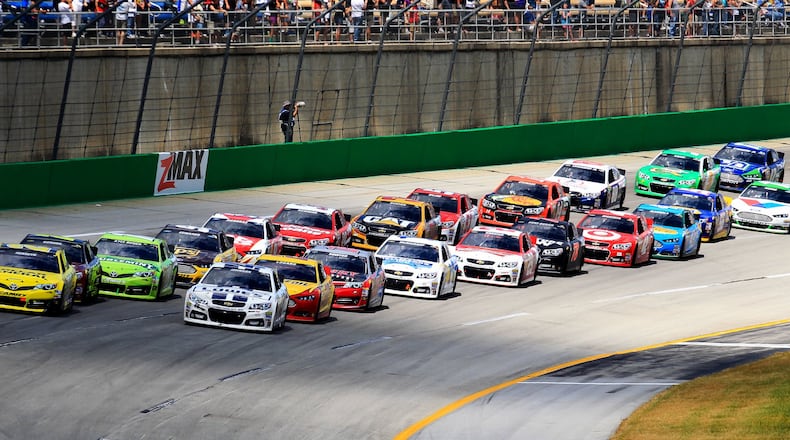 Matt Kenseth (20) and Jimmie Johnson (48) lead the field during a restart after a late caution in Sunday’s Quaker State 400 race at Kentucky Speedway June 30, 2013. NICK DAGGY / STAFF