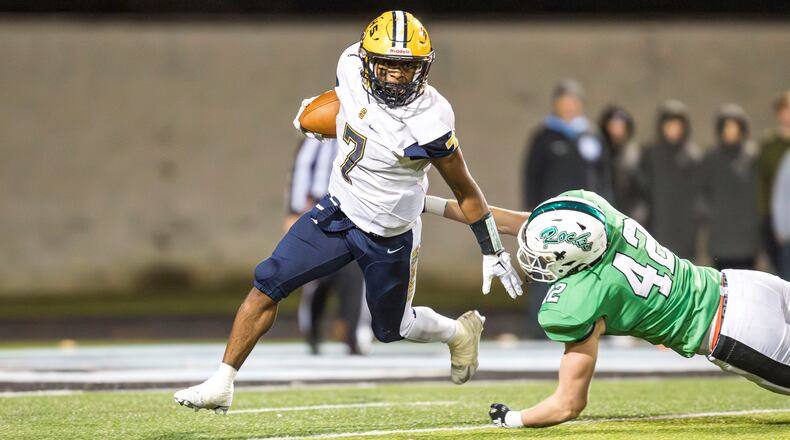 Springfield High School senior Jayvin "BayBay" Norman runs past Dublin Coffman senior Charlie Mitchell during their game on Friday night at Hilliard Darby Stadium. Norman scored two touchdowns as the Wildcats won 21-14, winning their fifth straight Division I, Region 2 championship. Michael Cooper/CONTRIBUTED
