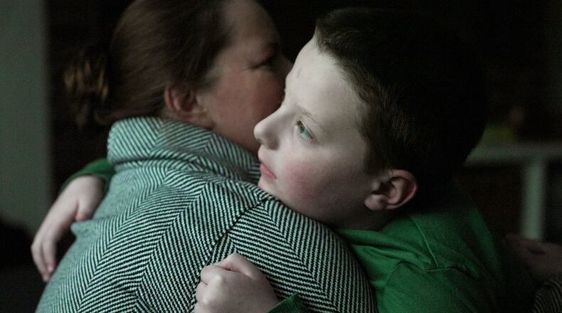 Ronan Murphy hugs his mother, Andrea, while looking at the snow falling outside their home in Ayer, Mass., on Saturday, Jan. 17, 2026. (AP Photo/Shelby Lum)