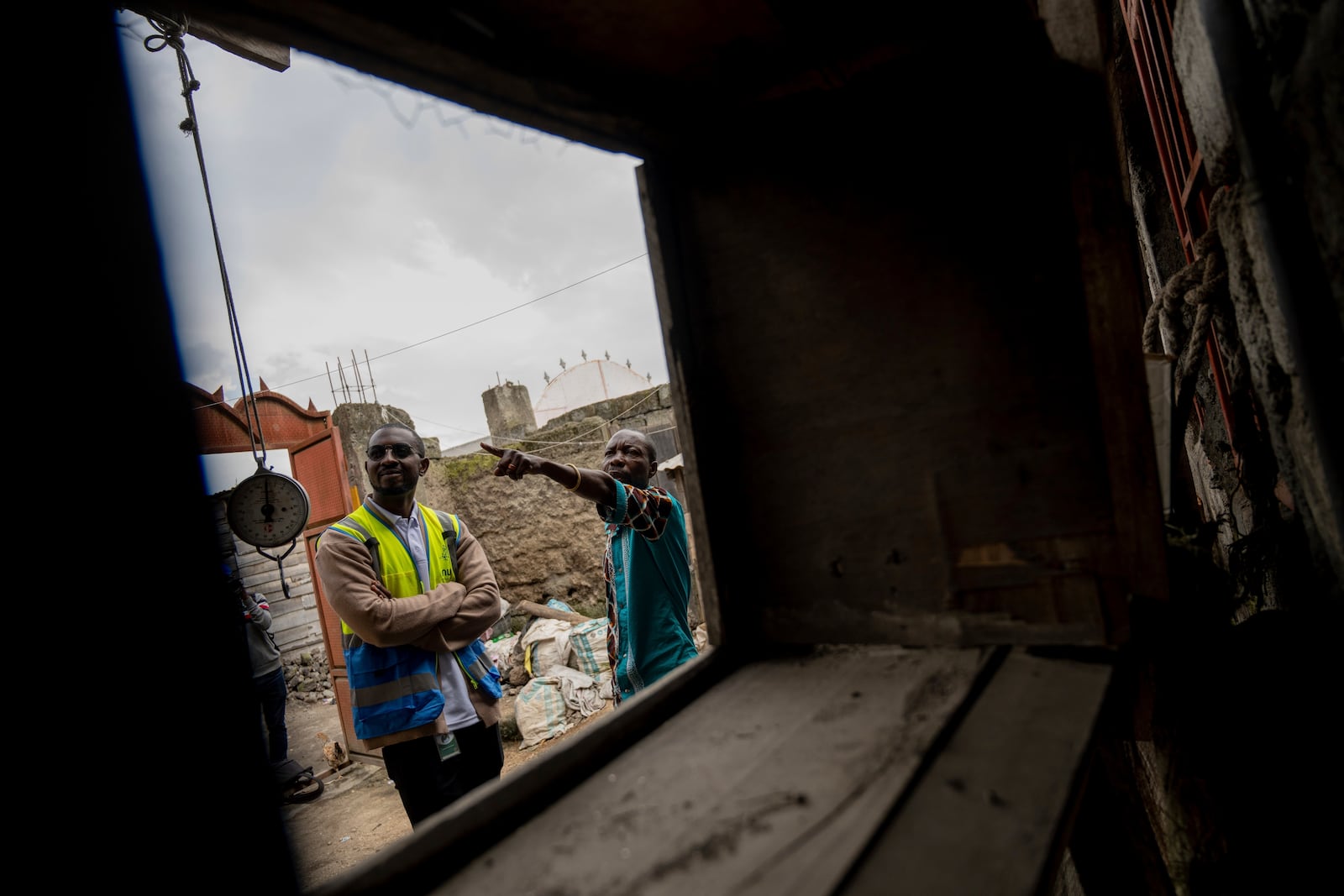 Choma Choma Mayuto Banga, right, who uses power at his home from a solar energy, talks with a customer service representative in Goma, Congo, May 23, 2024. (AP Photo/Moses Sawasawa)