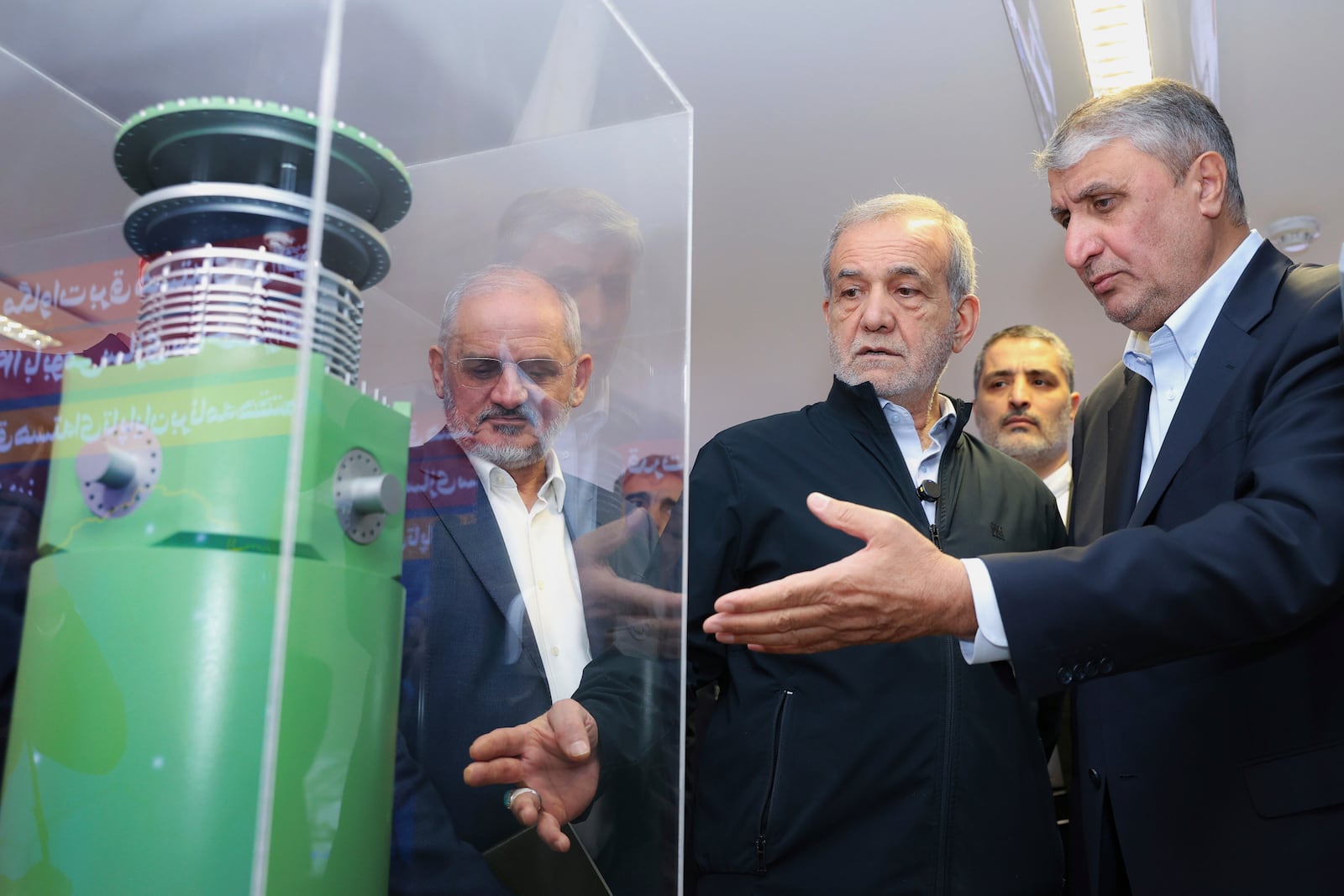 FILE - In this photo released by the Iranian Presidency Office, President Masoud Pezeshkian, second right, listens to Head of the Atomic Energy Organization of Iran Mohammad Eslami as he visits an exhibition of Iran's nuclear achievements in Tehran, Iran, April 9, 2025. (Iranian Presidency Office via AP)