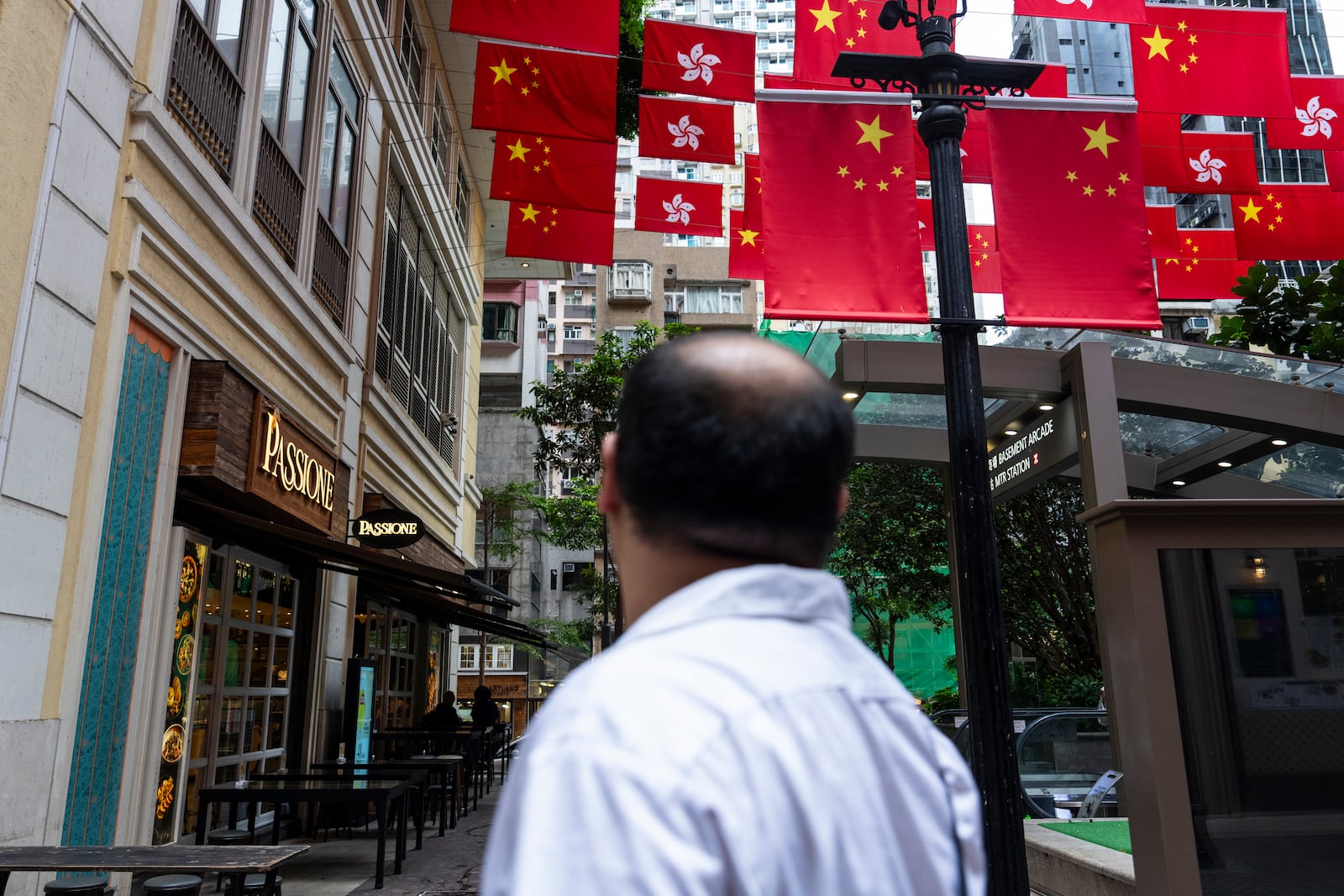 Chinese and Hong Kong SAR flags are hung outside restaurants in Hong Kong, Thursday, June 26, 2025. (AP Photo/Chan Long Hei)