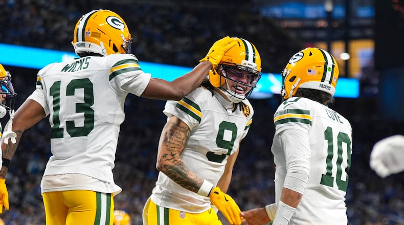Green Bay Packers wide receiver Christian Watson (9) celebrates a touchdown with wide receiver Dontayvion Wicks (13) and quarterback Jordan Love (10) against the Detroit Lions during the second half an NFL football game in Detroit, Thursday, Nov. 27, 2025. (AP Photo/Ryan Sun)