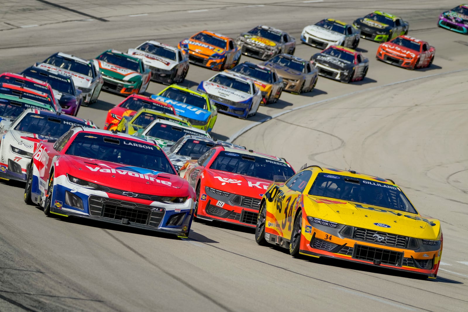Kyle Larson, front left, and Todd Gilliland, front right, lead the pack following a caution during a NASCAR Cup Series auto race at Texas Motor Speedway in Fort Worth, Texas, Sunday, May 4, 2025. (AP Photo/Larry Papke)