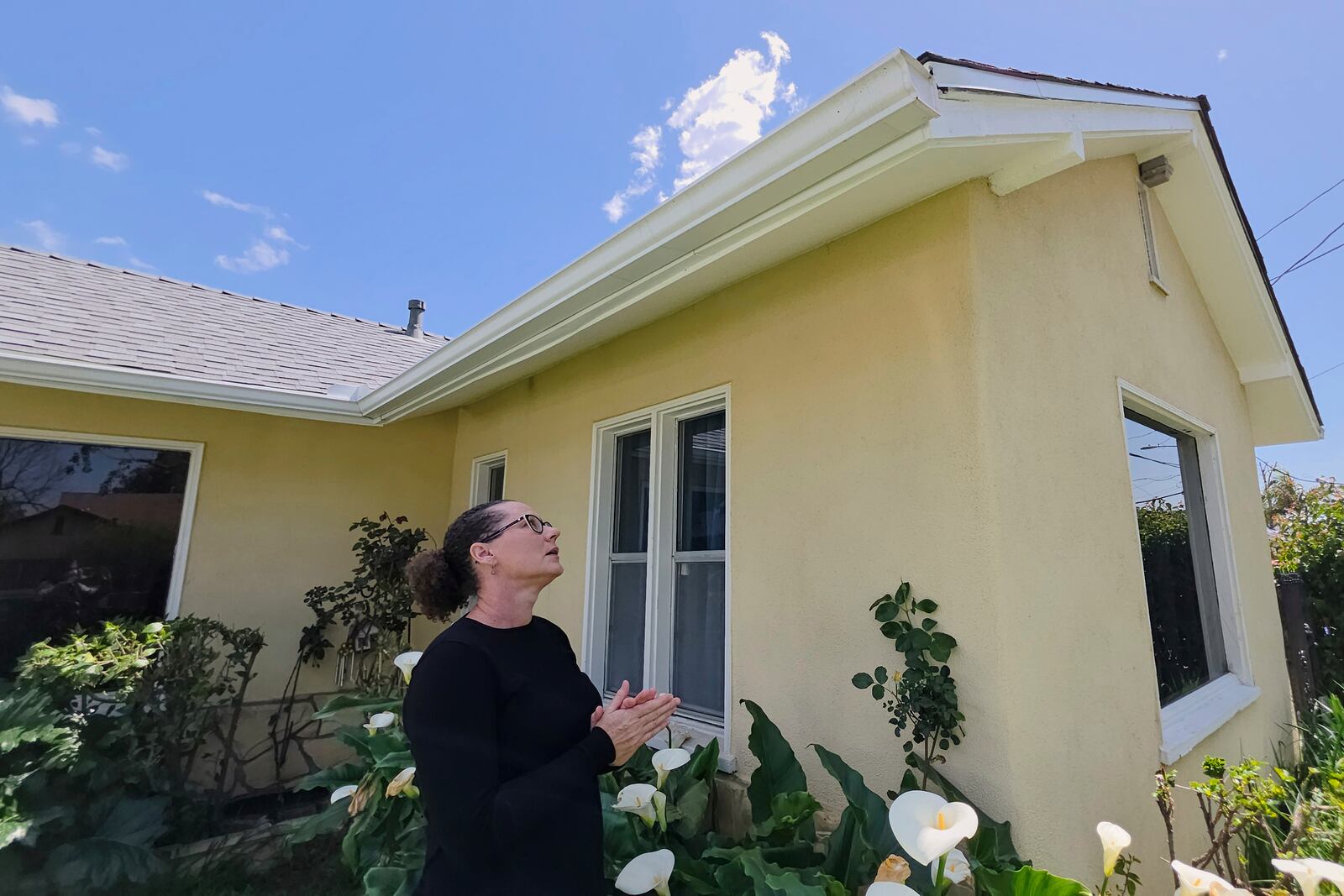 Eaton fire survivor Dr. Nicole Maccalla, a data scientist and a lead investigator, checks her roof's repairs made to her smoke damaged home in Altadena, Calif., on Friday, April 4, 2025. (AP Photo/Damian Dovarganes)