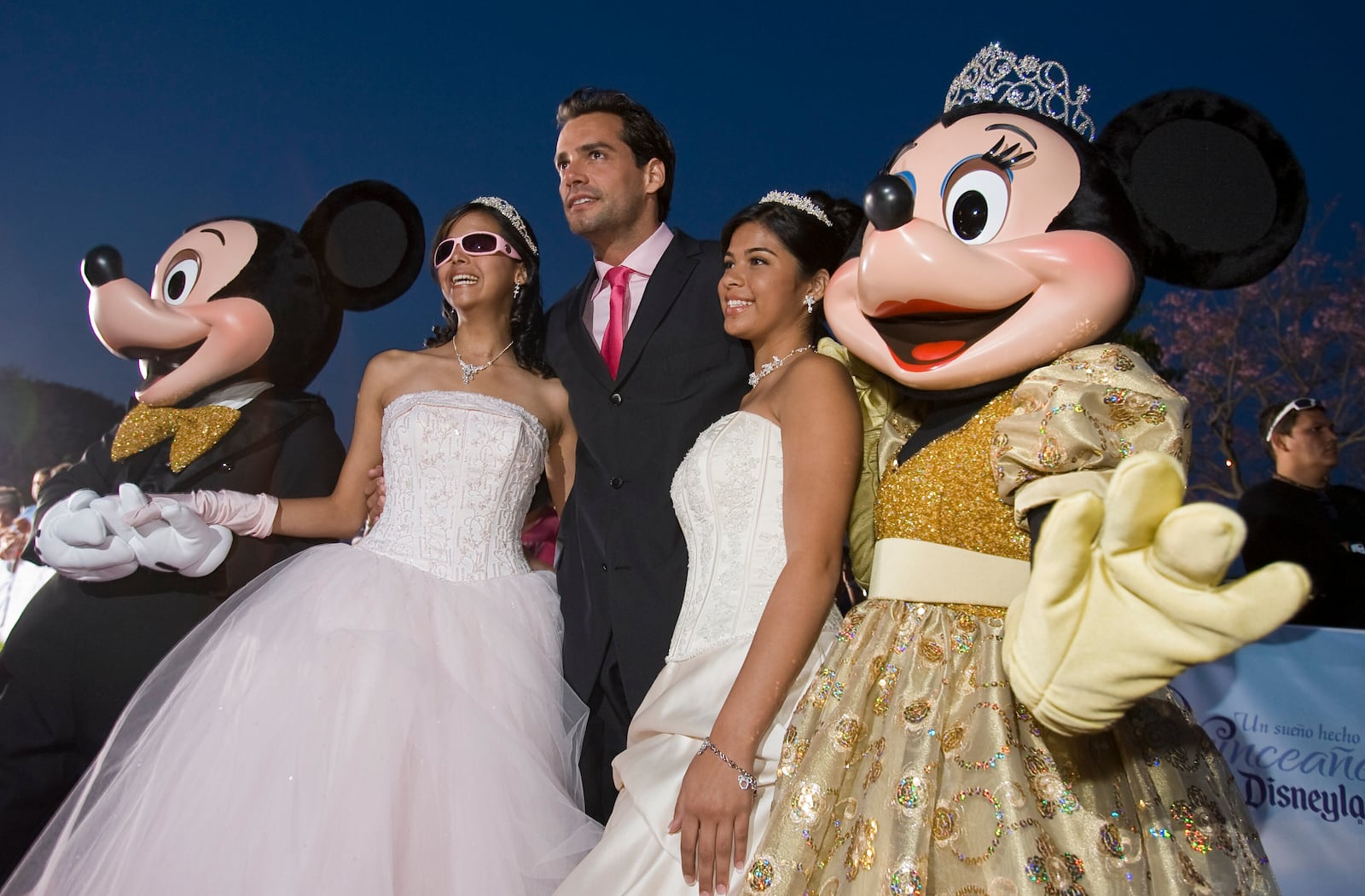 FILE - Actor Cristian de la Fuente, center, poses for photos with Shalmary Arroyo, left, Amethist Martinez, right, and Mickey and Minnie Mouse on the red carpet as 15 young ladies from across the United States and Puerto Rico were given an opportunity celebrate their Quinceañera at Disneyland Resort in Anaheim, Calif., April 24, 2008. (AP Photo/Mark Avery, File)