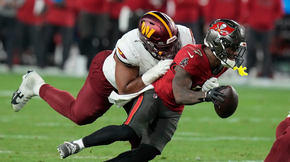 Tampa Bay Buccaneers running back Bucky Irving, right, runs against Washington Commanders defensive tackle Jonathan Allen during the second half of an NFL wild-card playoff football game in Tampa, Fla., Jan. 12, 2025. (AP Photo/Chris O'Meara, file)