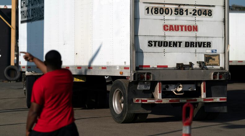 FILE - A student driver helps his classmate steer the wheel into the right direction as they practice driving in reverse in Calif., Nov. 17, 2021. (AP Photo/Jae C. Hong, File)