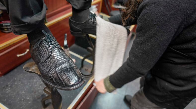 Bertha Gomez shines a customer's shoes at the Alpha Shoe Repair Corp., Friday, Feb. 3, 2023, in New York. Once a common practice, the tradition of getting a quick polish from a rag-toting shoeshine has become more of a rarity, and many stands have disappeared across the country. (AP Photo/Mary Altaffer)