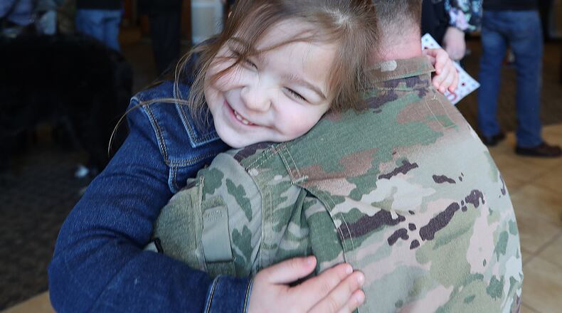 Emelyn Willis, 4, hugs her daddy Maj Aaron Willis during a Welcome Home Ceremony Saturday for the Ohio National Guard’s 371st Sustainment Brigade, headquartered in Springfield.