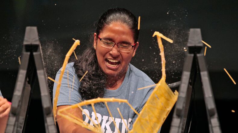 Springfield News-Sun Photographer Bill Lackey won first place feature photo for this image. Rochelle Fernando, from Fairborn High School, reacts as her noodle bridge collapses during the Engineering Innovation Bridge Competition at Clark State Community College in Springfield. Teams comprised of students int the Engineering Innovation program, sponsored by Clark State and Johns Hopkins University, built bridges with 250 grams for pasta and epoxy. The bridges then were compared to see how much weight they could hold before they broke. The winning bridge held 30 pounds. Bill Lackey/Staff