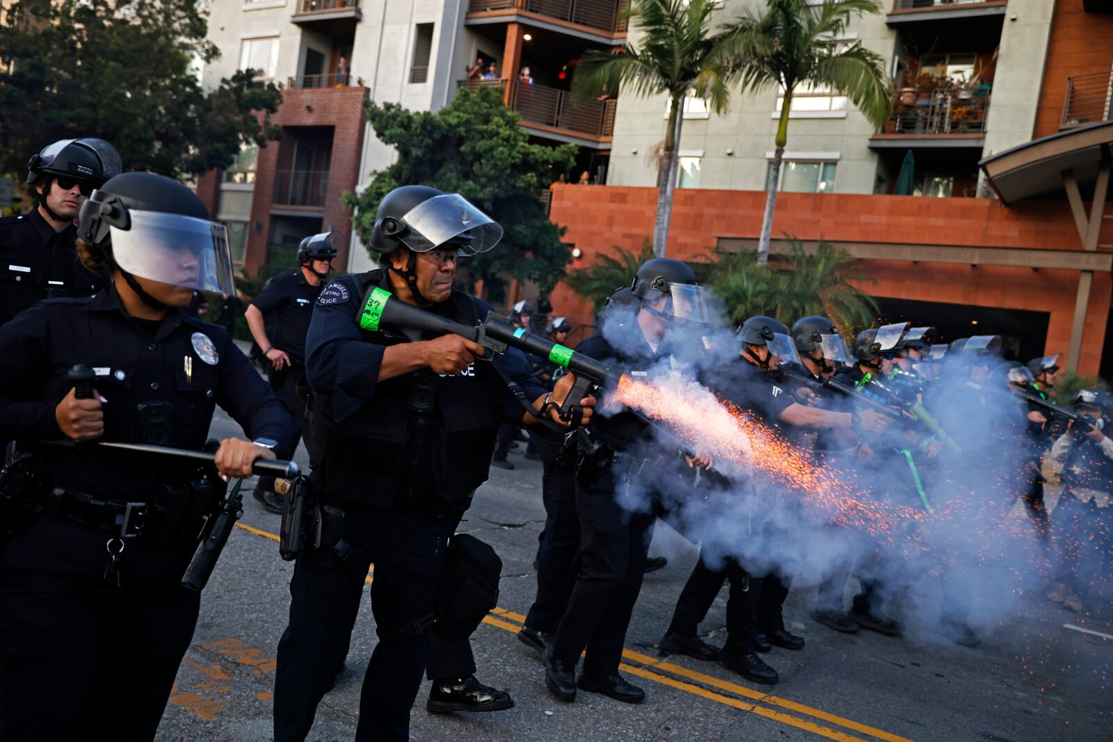 A Los Angeles Police Department officer shoots less-than-lethal munitions toward demonstrators during a protest in response to a series of United States Immigration and Customs Enforcement (ICE) raids, in Los Angeles, on Monday, June 9, 2025. (Stephen Lam/San Francisco Chronicle via AP)