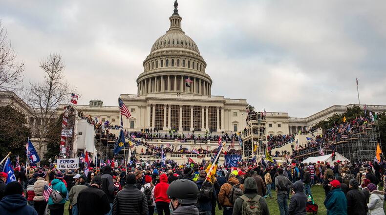A pro-Trump mob storms the Capitol in Washington after a rally where the president spoke, urging them on, Jan. 6, 2021. Experts say the actions of President Donald Trump and his loyalists are harder to stop than a coup — citing anti-democratic slides in Turkey and Venezuela as closer examples. (Jason Andrew/The New York Times)
