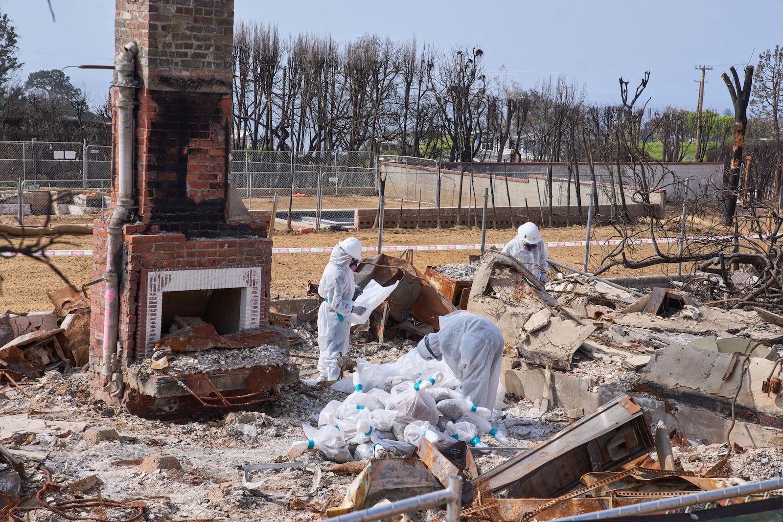 Cal/OSHA workers remove hazardous materials from a home destroyed by the Palisades Fire in the Pacific Palisades neighborhood of Los Angeles, Thursday, April 24, 2025. (AP Photo/Damian Dovarganes)
