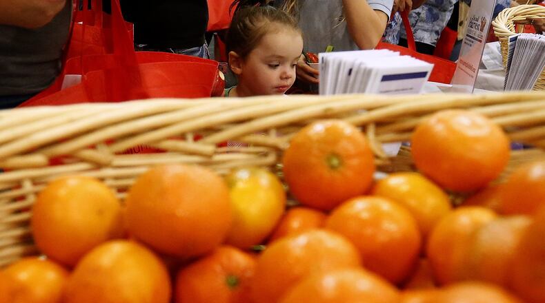 Peyton Love, 2, looks over the nutrition information next to a basket a oranges at the Second Harvest Food Bank’s booth at the Healthy Family Expo on Oct. 4. Bill Lackey/Staff