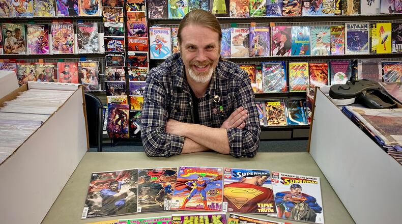 Peter Bell, owner of Bell Book and Comic in Dayton,shows off a selection of Superman and an Incredible Hulk comics. Both superheroes have Ohio connections. LONDON BISHOP/STAFF