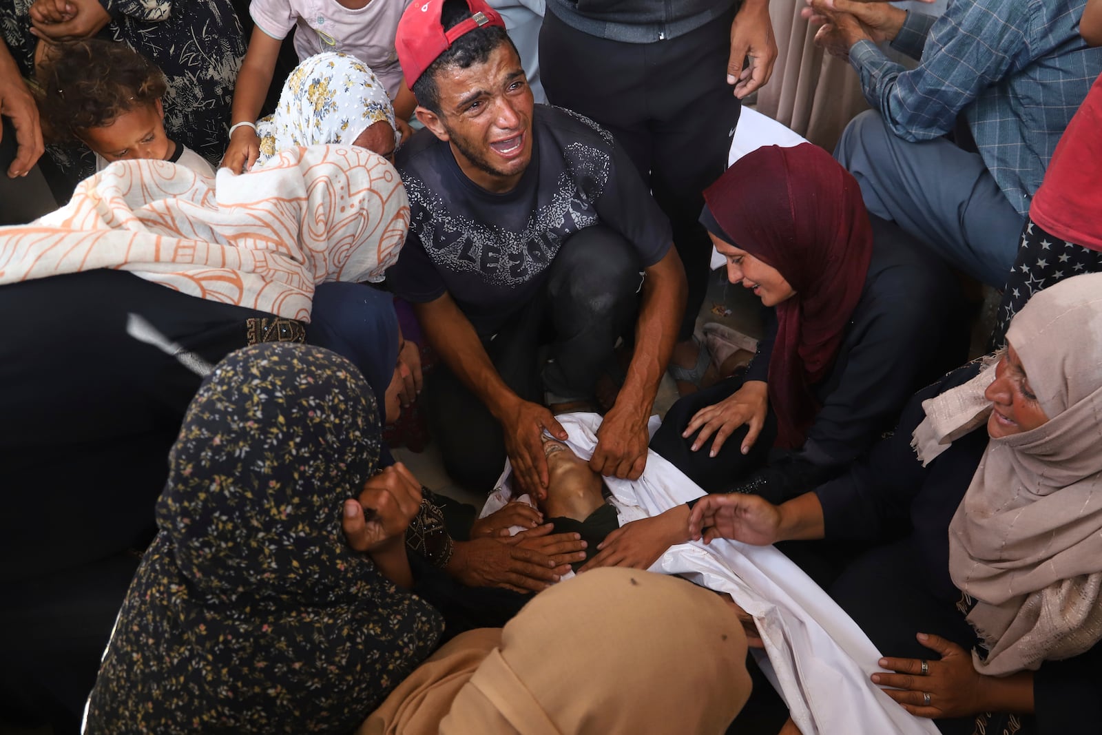 Palestinian relatives mourn over the body of a man killed in an Israeli strike, at Nasser Hospital in Khan Younis, southern Gaza Strip, Tuesday, June 17, 2025. (AP Photo/Mariam Dagga)