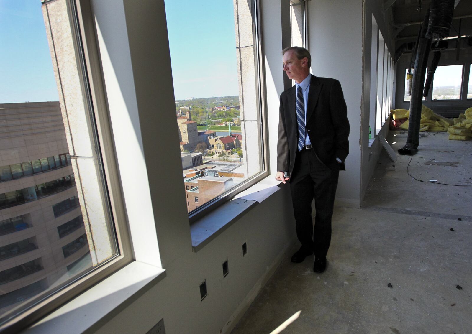 In a 2012 photo, Premier Health director of real estate Buddy LaChance looks out over the city from the 18th floor of Premier's then-new home at 110 N. Main St. Staff file photo by Jim Witmer