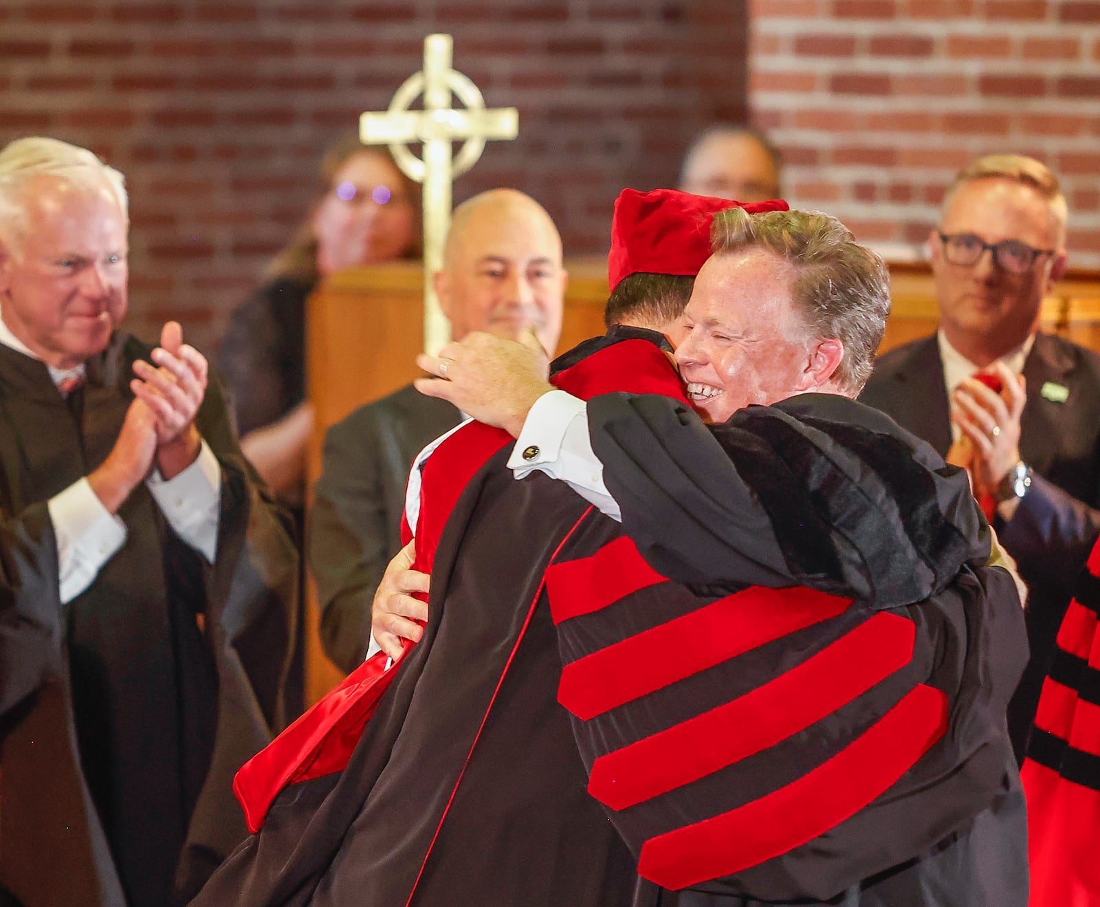 Bill Edwards, center, chair of Wittenberg University Board of Directors, greets Rev. Dr. Christian M.M. Brady during his inauguration on Friday, October 17, 2025, at Wittenberg University's Weaver Chapel. JOSEPH COOKE/STAFF
