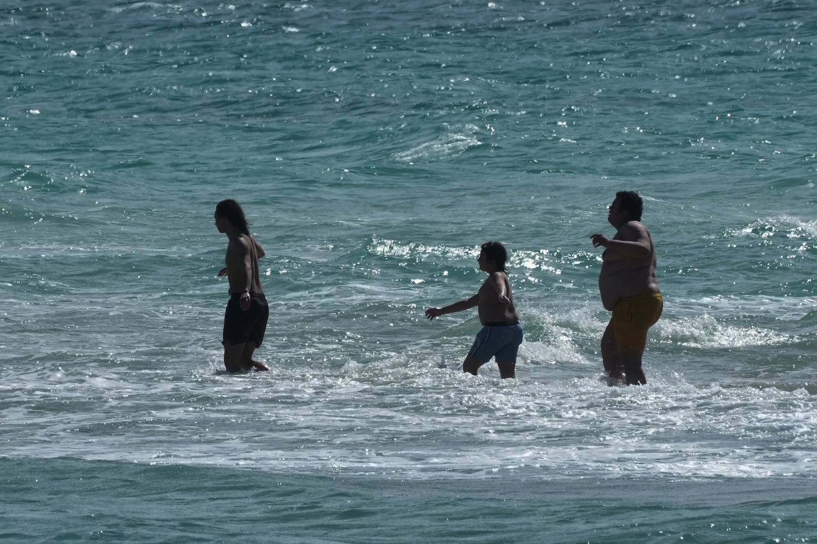 Beachgoers brave the cold ocean temperature while walking on a sandbar Thursday, Jan. 29, 2026, in Miami Beach, Fla. (AP Photo/Marta Lavandier)