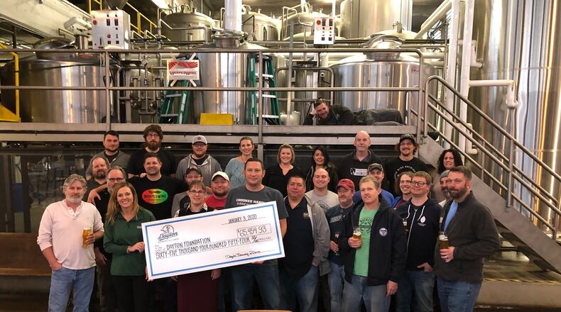 Members of the Dayton Brewery Alliance gathered Friday afternoon at Warped Wing Brewing Company in downtown Dayton to present a check for $65,454 to the Dayton foundation’s tornado-relief fund. The money was raised entirely from the sales and contributions of #DaytonStrong IPA, a special collaborative brew among local breweries. MARK FISHER/STAFF