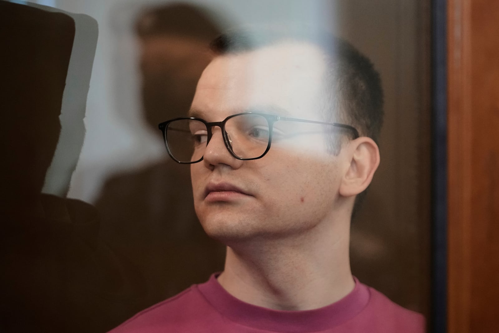 Russian journalist Artyom Kriger, accused of working for a group founded by the late Russian opposition politician Alexei Navalny, stands in a defendant's cage of the Nagatinsky District Court in Moscow, Russia, on Tuesday, April 15, 2025. (AP Photo)