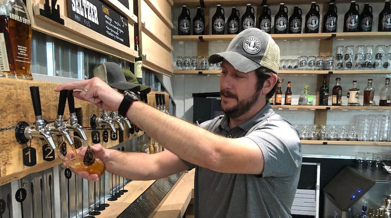 Matt Foster, general manager of the recently opened Urbana Brewing Co., pours a handcrafted beer from one of six taps. Jobs, housing and amenities are part of what Champaign County leaders have called a renaissance in their community.