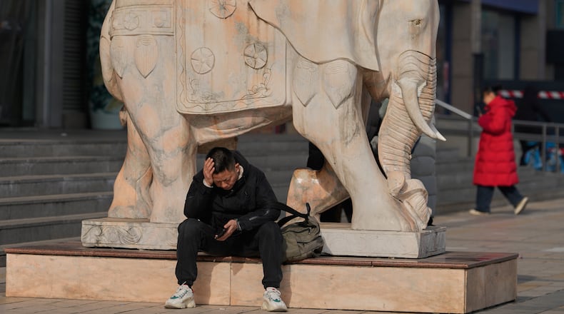 A man reacts while holding his smartphone in Beijing, China, Thursday, Jan. 15, 2026. (AP Photo/Ng Han Guan)