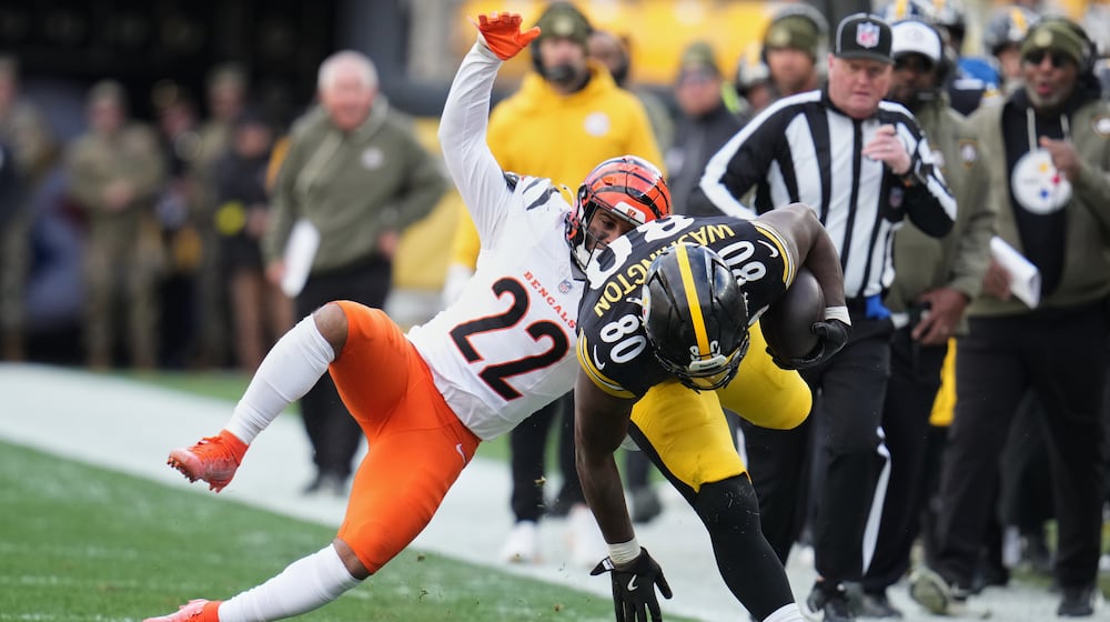 Pittsburgh Steelers tight end Darnell Washington (80) avoids a tackle by Cincinnati Bengals safety Geno Stone (22) during the first half of an NFL football game Sunday, Nov. 16, 2025, in Pittsburgh. (AP Photo/Gene J. Puskar)