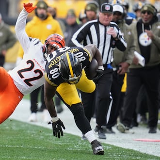 Pittsburgh Steelers tight end Darnell Washington (80) avoids a tackle by Cincinnati Bengals safety Geno Stone (22) during the first half of an NFL football game Sunday, Nov. 16, 2025, in Pittsburgh. (AP Photo/Gene J. Puskar)