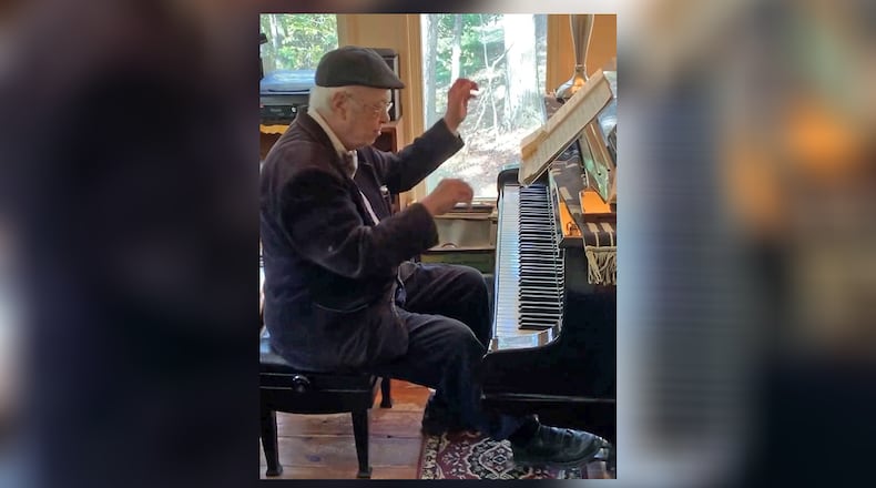 An older Howard Tuvell plays his $100,000 August Forster grand piano at his Danbury, Connecticut, home. CONTRIBUTED PHOTO